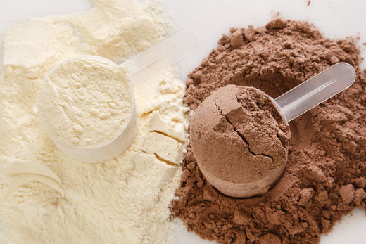 Kakaolu ve vanilyalı protein tozu serpilmiş, dolu protein ölçekleriyle birlikte – sporcu beslenmesi ve antrenman sonrası protein desteği görseli
